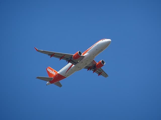 Avion easyJet rouge et blanc décollant vers un ciel bleu dégagé