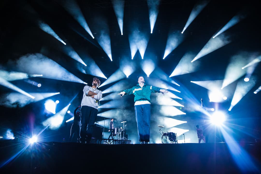 Macklemore & Ryan Lewis sur la grande scène du Paléo Festival, éclairés par des projecteurs bleus et blancs, pendant leur concert