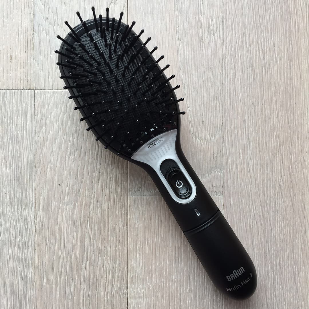 Brosse Braun Satin Hair 7 IONTEC noire et blanche aux poils synthétiques, posée sur un fond gris clair
