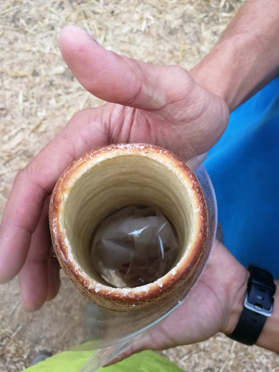 Kürtőskalács à la cannelle tenu dans une main, pâtisserie hongroise creuse fourrée de chocolat