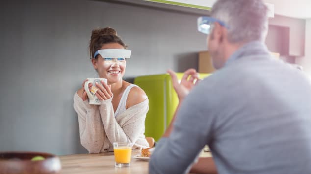 Femme portant les lunettes Luminette blanc et bleu lors d'une conversation avec un homme à une table