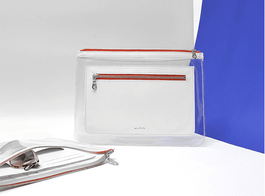 Wallet Barnett de Marlich en cuir blanc avec détails en rouge brique, fermé par fermeture-éclair, présenté sur fond blanc et bleu