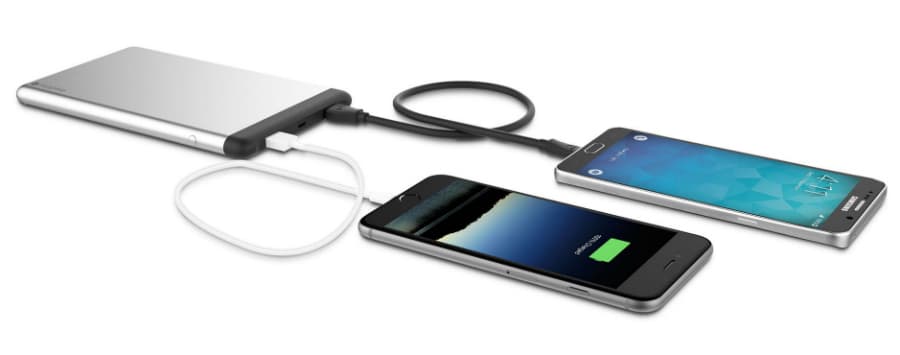 Batterie externe compacte argentée branchée sur deux smartphones en charge via câbles USB
