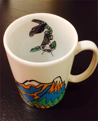 Tasse blanche de la collection SPRIDD avec motifs colorés stylisés d'insecte et de paysage, intérieur et extérieur décorés