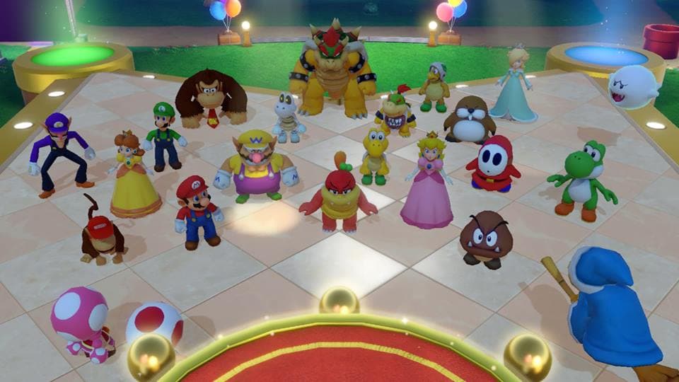 Plateau de jeu de Super Mario Party avec une dizaine de personnages colorés disposés sur une place centrale, parmi lesquels Mario, Bowser, Peach et Yoshi
