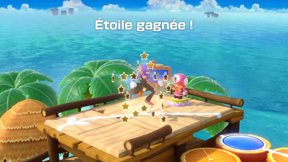 Écran de Super Mario Party montrant deux personnages sur une plateforme en bois avec texte « Étoile gagnée » sur fond tropical