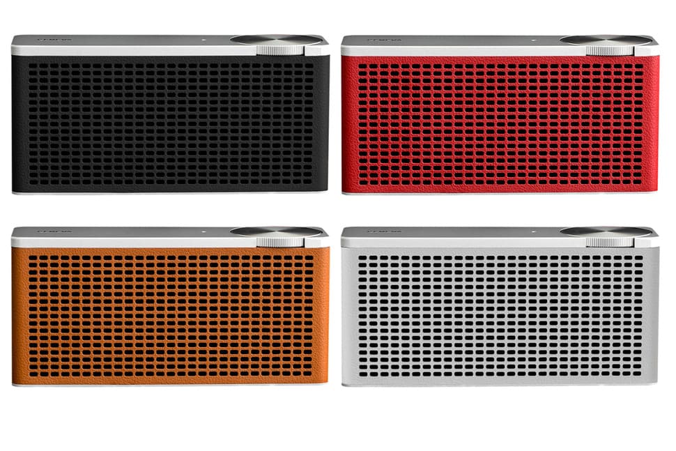 Quatre enceintes Geneva Touring/xS de couleurs différentes : noire, rouge, orange et blanche, avec grille de haut-parleur perforée