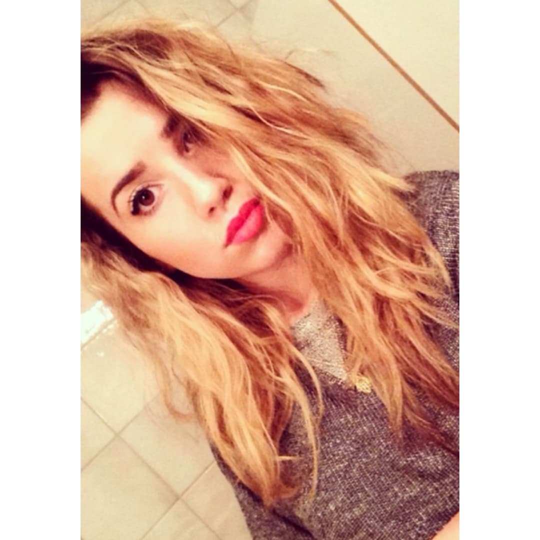 Femme aux longs cheveux blonds dorés ondulés, regard vers l'appareil photo, lèvres roses