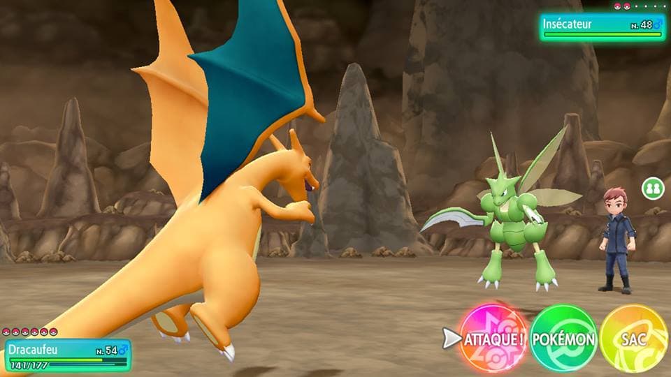 Capture d'écran de Pokémon Let's Go montrant un combat entre Dracaufeu orange et Insécateur vert dans une arène rocheuse