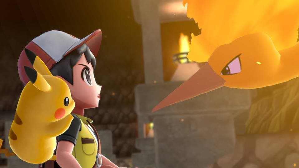Le dresseur Sacha avec Pikachu face à un Pokémon orange dans Pokémon Let's Go