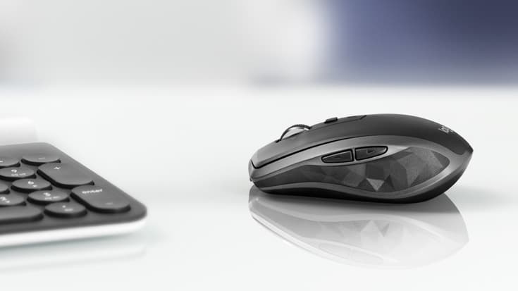Souris sans fil Logitech MX Anywhere 2S noire et grise, posée à côté d'un clavier
