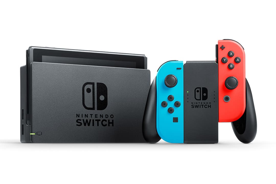 Console Nintendo Switch grise avec manettes détachables bleu et rouge, écran tactile, socle noir