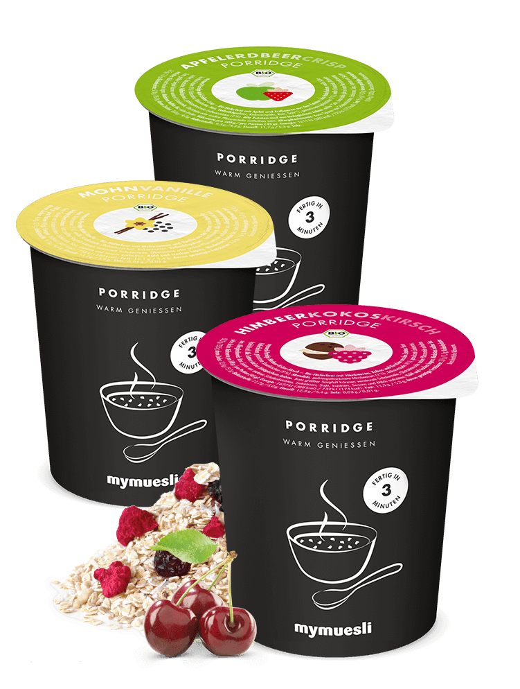 Trois pots noirs de porridge Mymuesli avec couvercles colorés vert, jaune et rose, accompagnés de flocons d'avoine, framboises et cerises