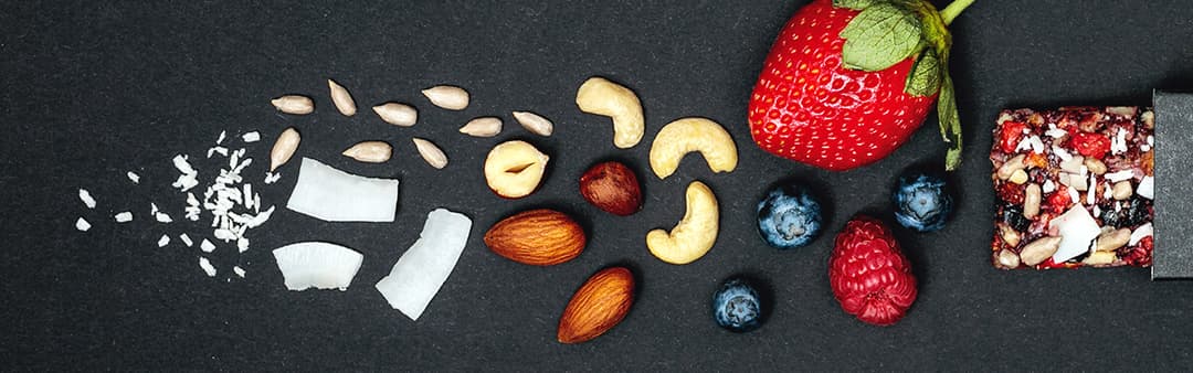 Ingrédients naturels pour barres de muesli : noix de coco, amandes, noix de cajou, fraise, myrtilles, framboise et mélange de céréales