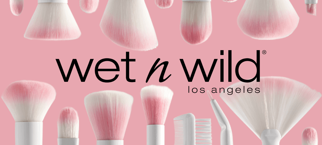 Pinceaux de maquillage aux poils rose et blanc, logo Wet n Wild Los Angeles sur fond rose pastel