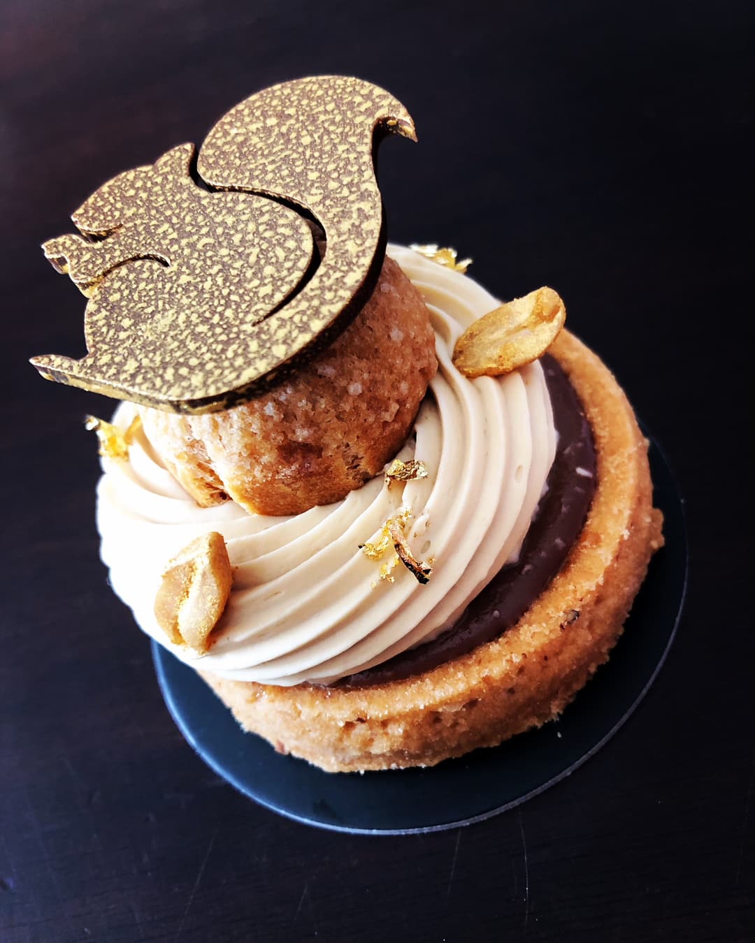 Tarte Écureuil du chef Damien Moutarlier : caramel, chocolat au lait et cacahuètes, décorée d'une feuille dorée