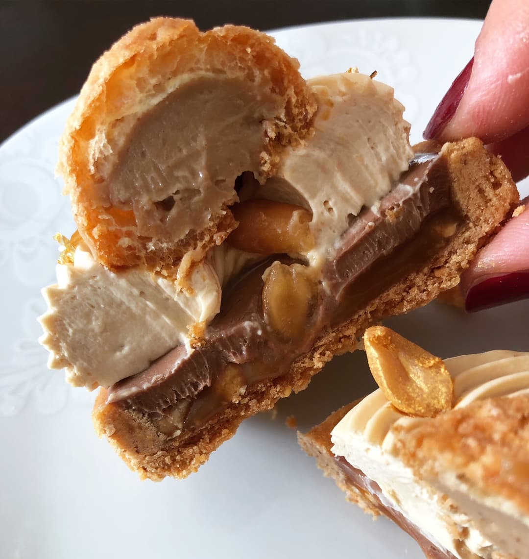 Tarte L'Écureuil du chef Damien Moutarlier : caramel, chocolat au lait, cacahuètes et mousse, coupée en deux pour montrer les couches
