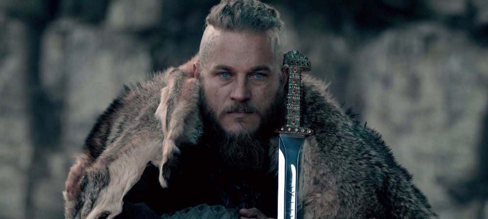Ragnar Lothbrok, guerrier viking à barbe blonde, vêtu d'une fourrure, tenant une épée ornementée