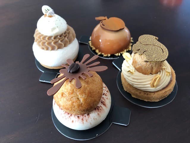 Assortiment de quatre pâtisseries du chef Damien Moutarlier : Tiramichou, tarte Écureuil, Meringué marron et chantilly vanille, Golden