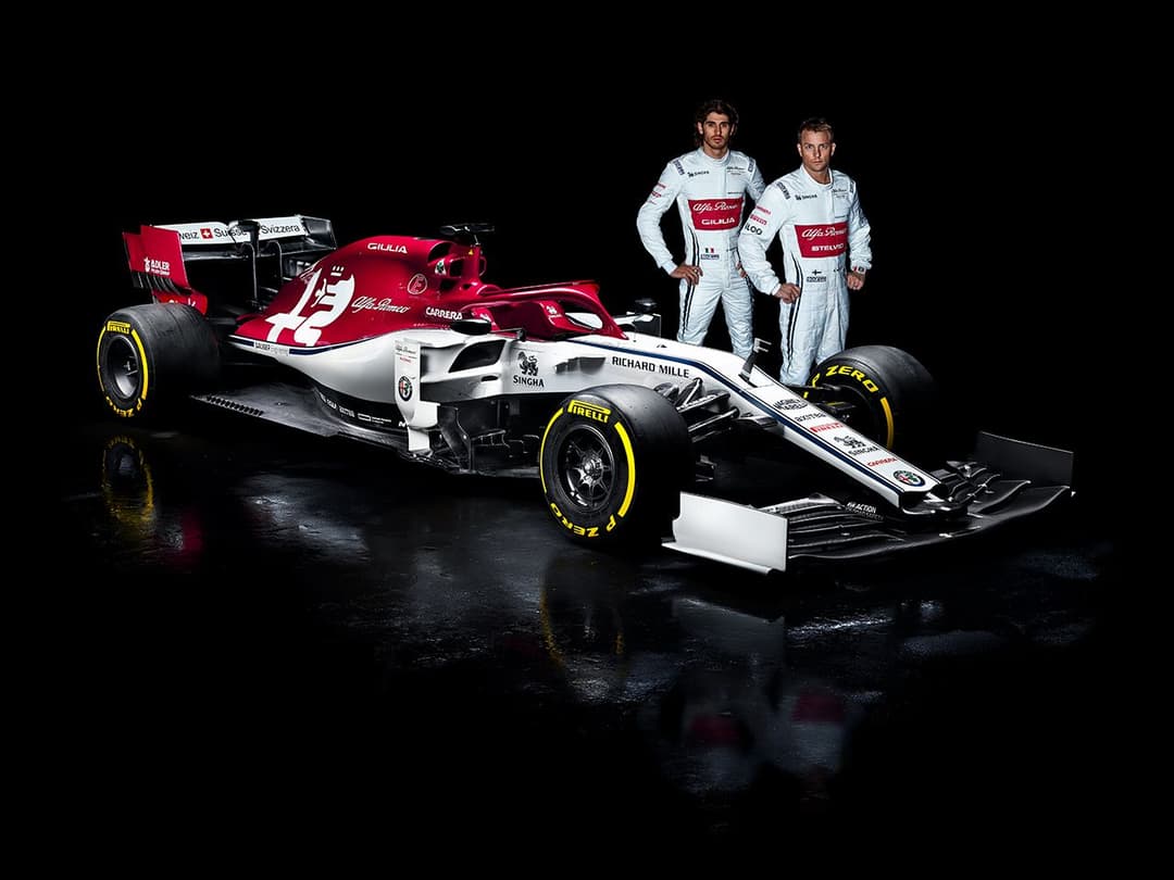 Monoplace Alfa Romeo Racing rouge et blanche avec deux pilotes en combinaison blanche posant à côté, sur fond noir