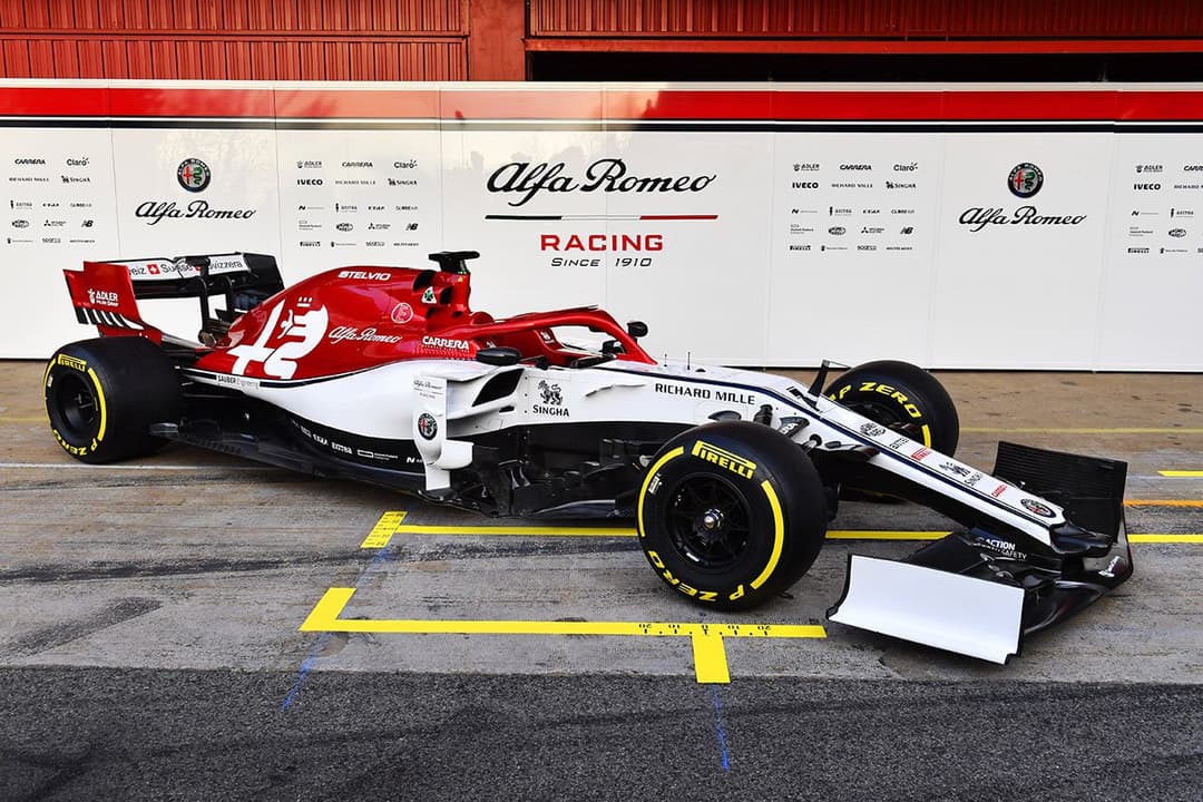 Monoplace de Formule 1 Alfa Romeo Racing aux couleurs rouge, blanc et noir, avec les logos de la marque italienne sur le cockpit et l'aileron arrière