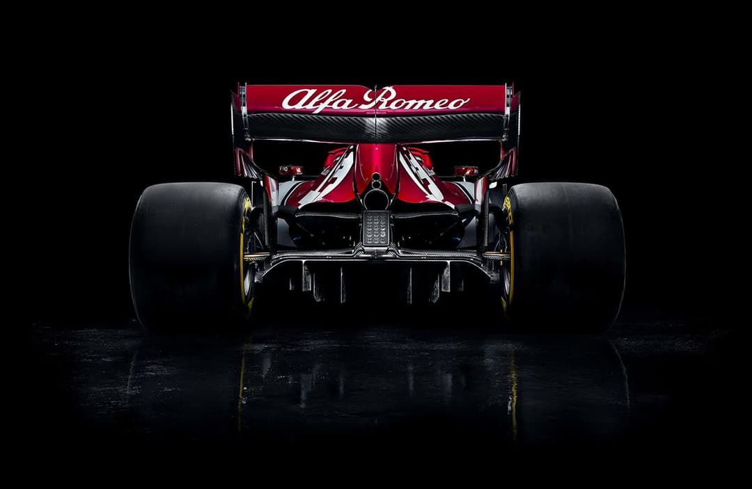 Monoplacedevue arrière aux couleurs rouge et noir d'Alfa Romeo Racing, présenté de face sur un fond noir