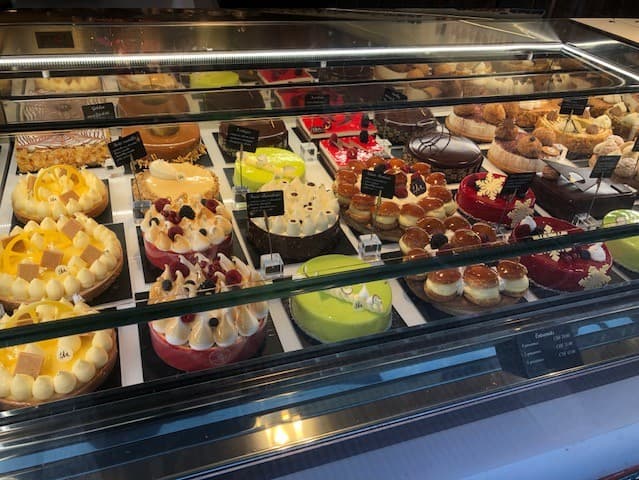 Vitrine réfrigérée de pâtisserie présentant des tartes, gâteaux et desserts variés aux fruits et chocolat
