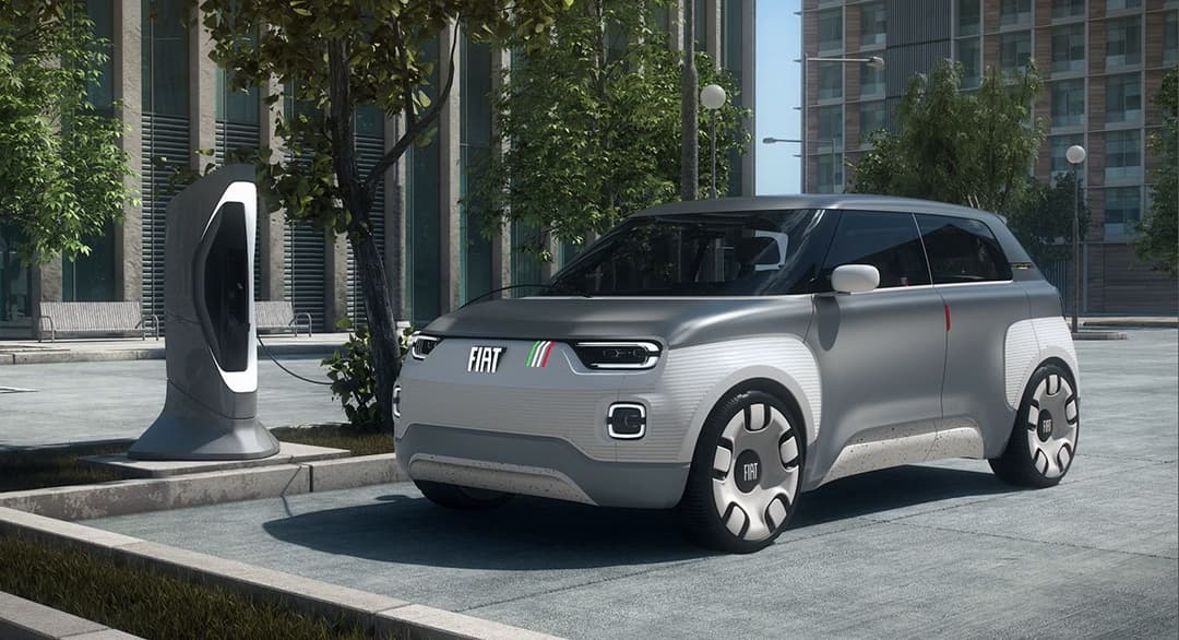 Concept-car Fiat Centoventi blanc et gris en recharge sur une borne de charging en milieu urbain