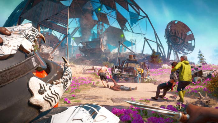 Un avant-poste de joueurs coloré dans Far Cry New Dawn, avec des structures métalliques, des fleurs violettes et des personnages en tenue jaune explorant le monde post-apocalyptique