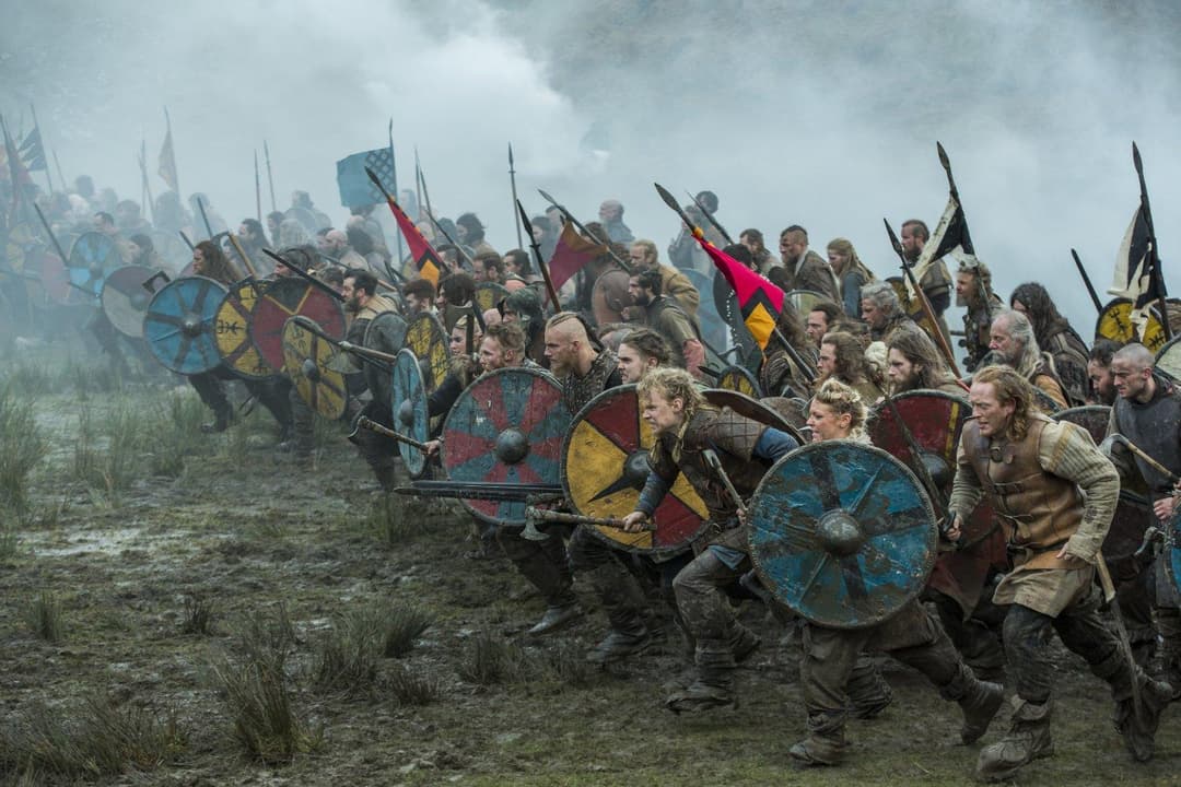 Guerriers vikings armés de boucliers colorés et de lances dans un paysage naturel brumeux