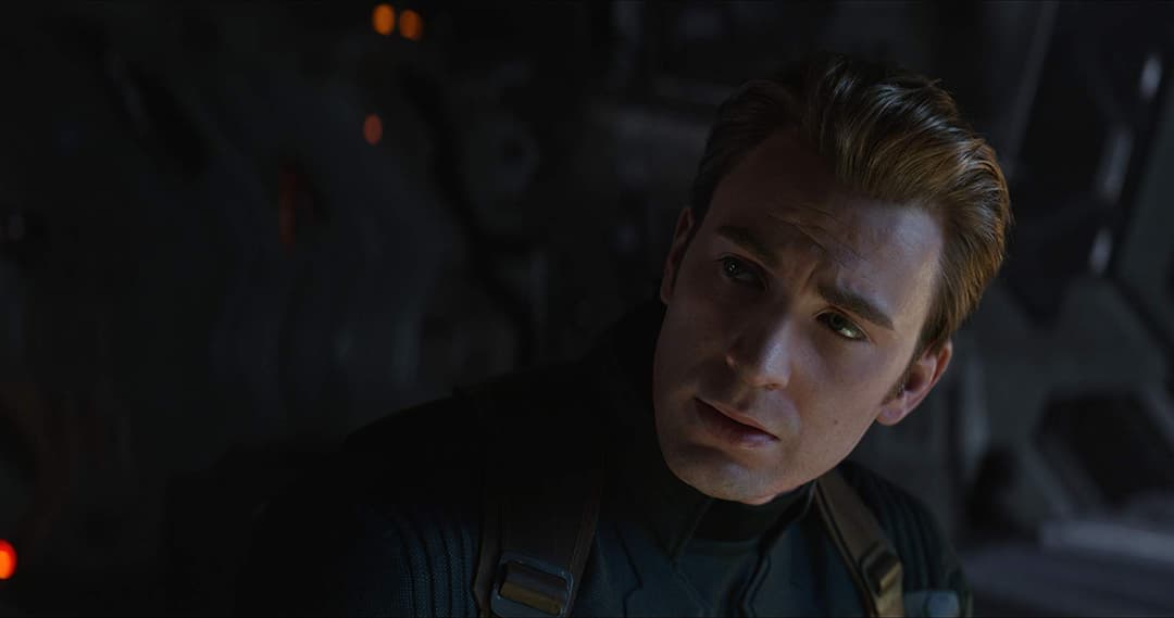 Captain America en costume bleu et argent dans une scène sombre d'Avengers: Endgame, regard intensif