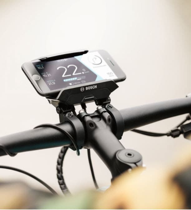 SmartphoneHub Bosch fixé au guidon d'un vélo électrique, affichant des données de trajet sur l'écran du smartphone