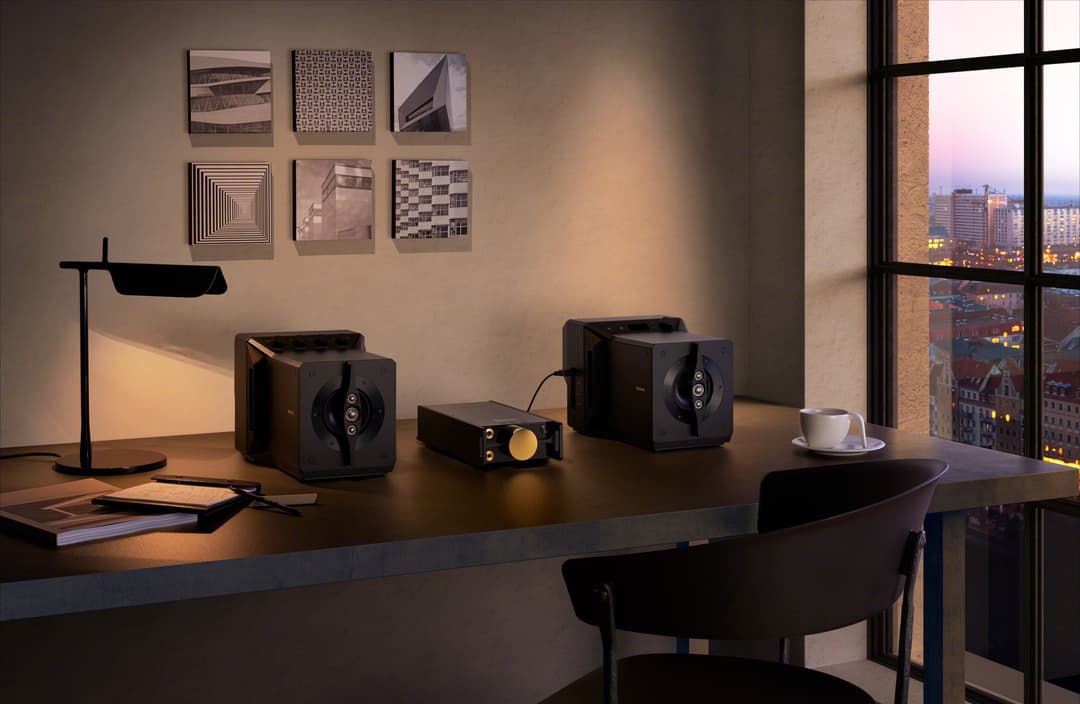 Système audio Sony SA-Z1 avec deux enceintes noires et amplificateur sur un bureau moderne, vue panoramique urbaine en arrière-plan