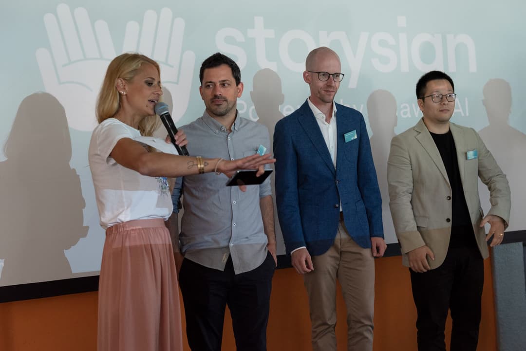 Quatre personnes présentent l'application Huawei StorySign sur une scène, avec le logo de l'application en arrière-plan
