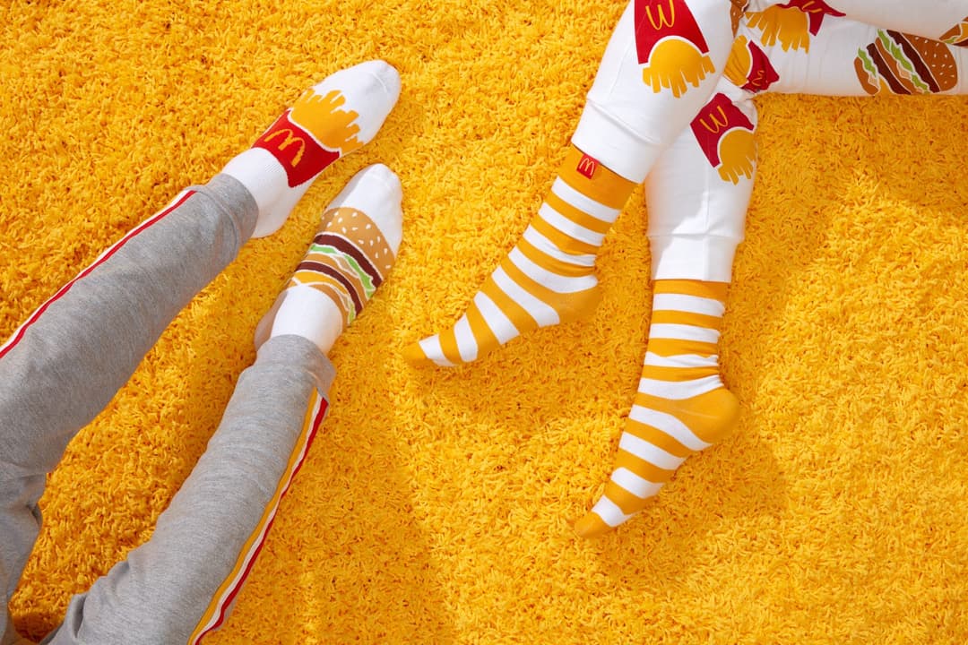 Paires de chaussettes McDonald's aux couleurs rouge, jaune et blanc, posées sur fond jaune