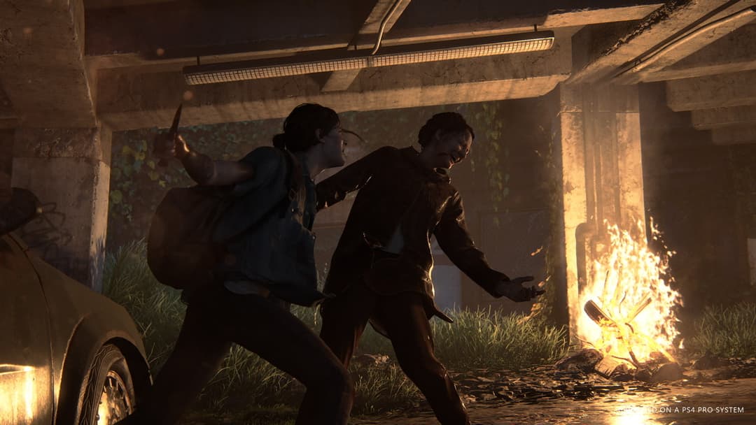 Deux personnages en conflit dans un garage souterrain désaffecté, illuminés par un feu, dans une scène de The Last of Us Part II