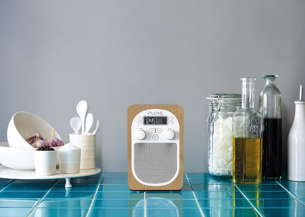 Radio numérique PURE Move T4 avec boîtier en bois clair et façade blanche, posée sur un plan de travail de cuisine