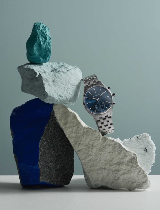 Montre connectée Kronaby Sekel Stainless Steel 41mm à cadran bleu acier, positionnée sur des pierres géométriques multicolores