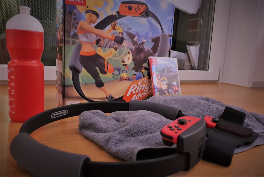 Accessoires Ring Fit Adventure : cerceau noir, Joy-Con rouges, sangle, serviette grise, bouteille d'eau rouge, boîte et jeu Nintendo Switch