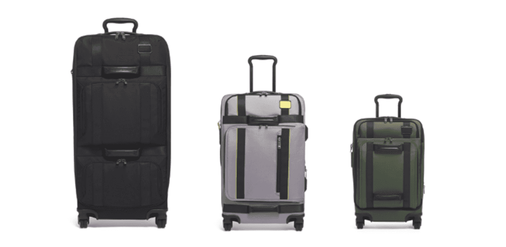 Trois valises TUMI de tailles différentes : noire, grise et vert olive, équipées de poignées rétractables et de roues