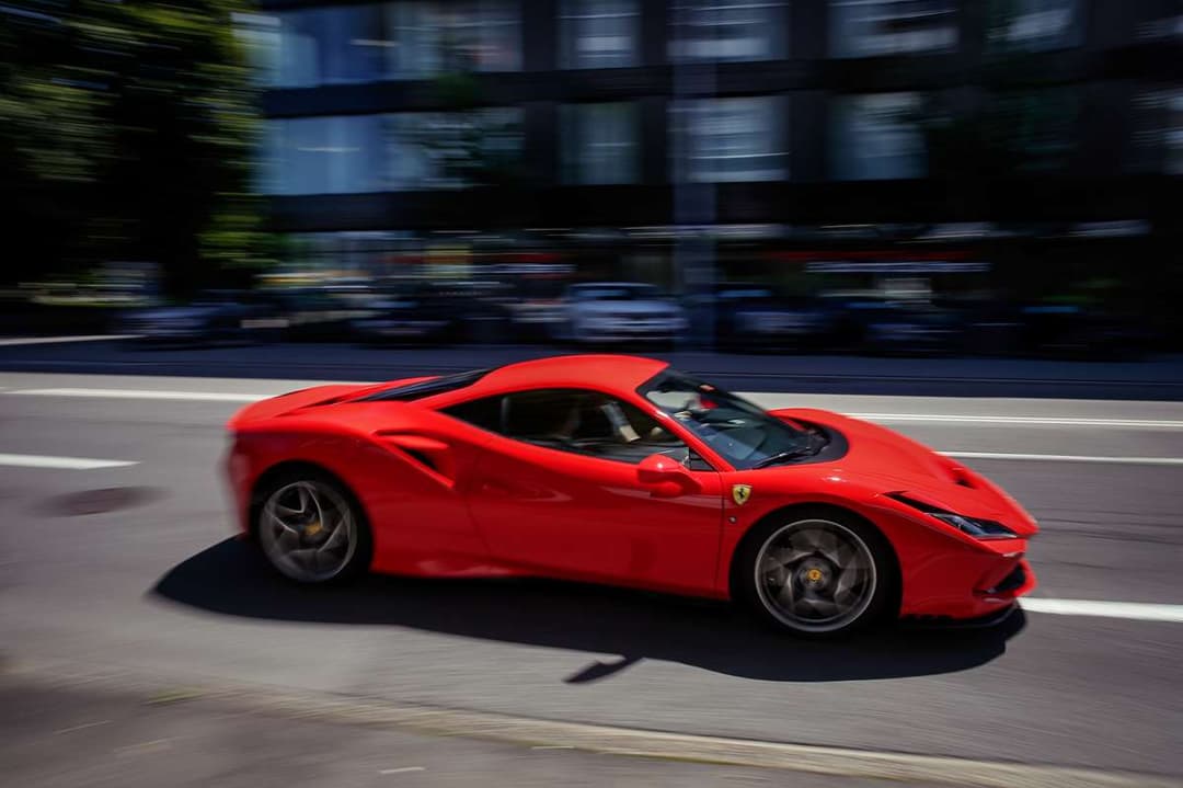 Ferrari F8 Tributo rouge vif en mouvement sur une route urbaine