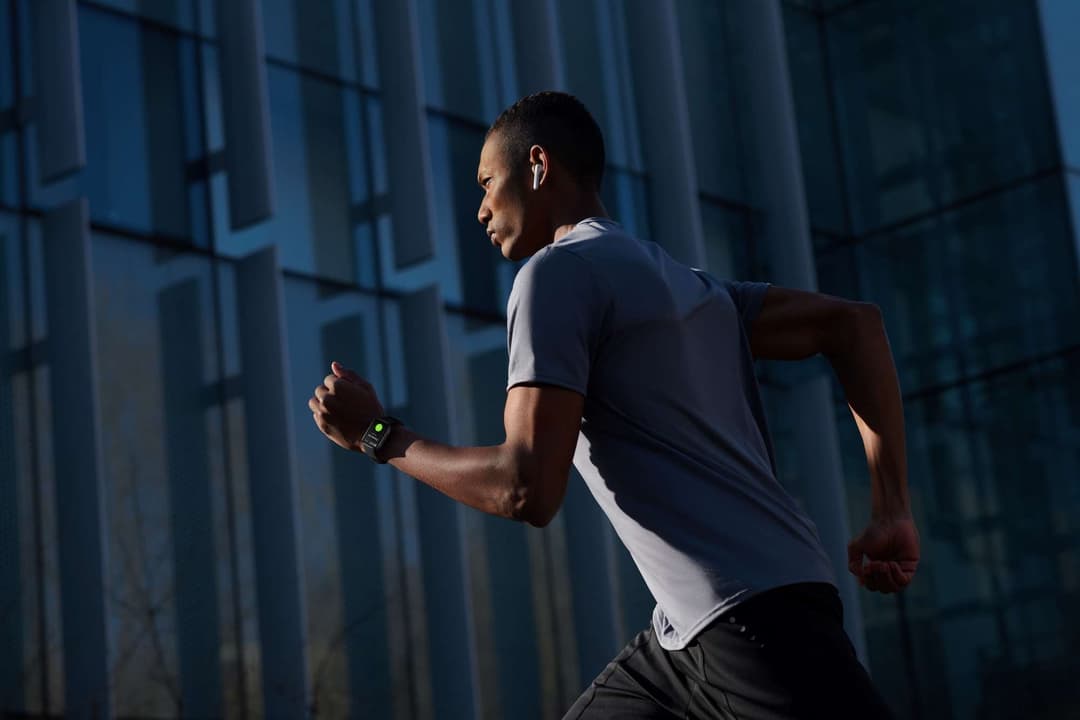 Homme en train de courir devant une façade bleue, portant une OPPO Watch au poignet