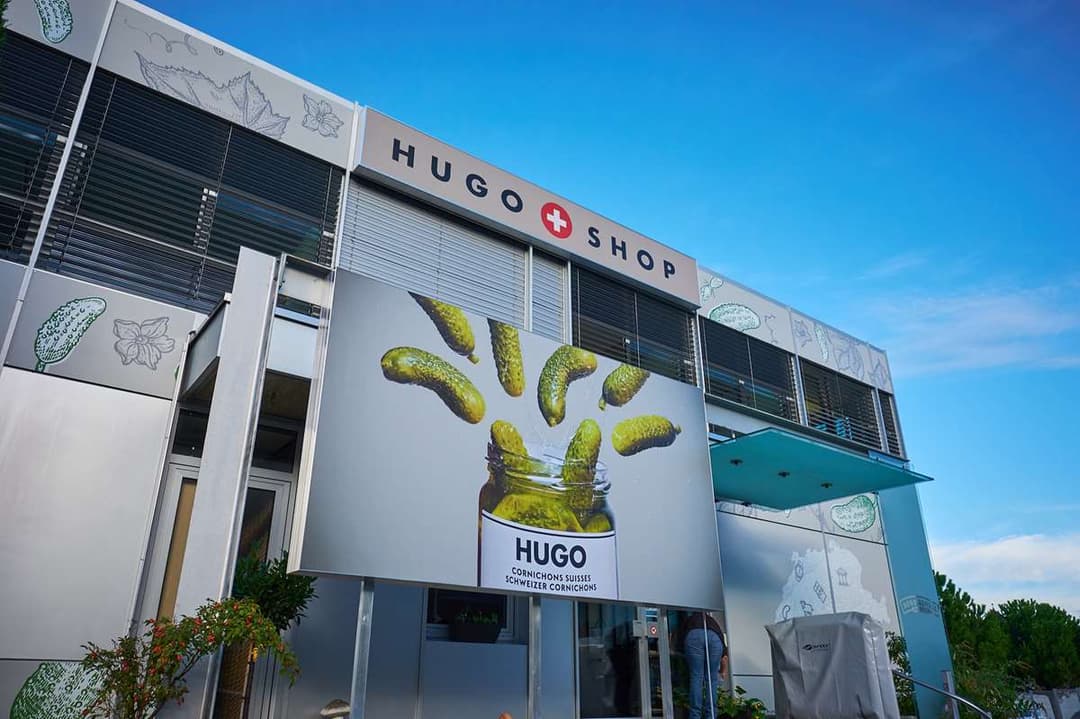 Façade du Hugo Shop, première boutique de Reitzel à Aigle, avec large affichage de cornichons suisses