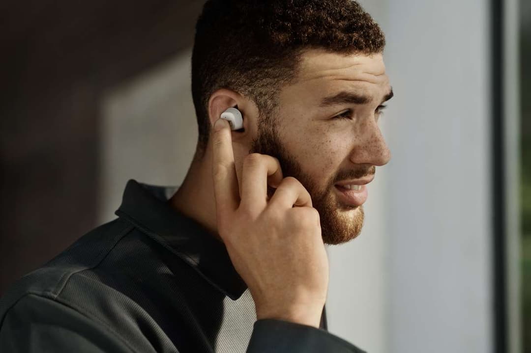 Écouteur blanc Sennheiser CX 400BT True Wireless porté à l'oreille d'un homme en vêtement noir