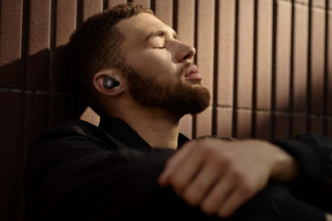 Écouteurs Sennheiser CX 400BT True Wireless noirs portés par un homme en profil, yeux fermés