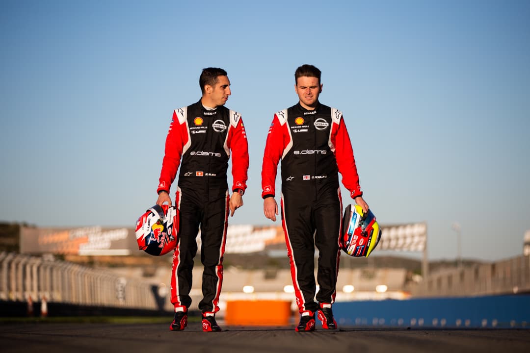 Sébastien Buemi et Oliver Rowland, pilotes Nissan e.dams, en combinaison de course rouge et noire, casque à la main sur un circuit
