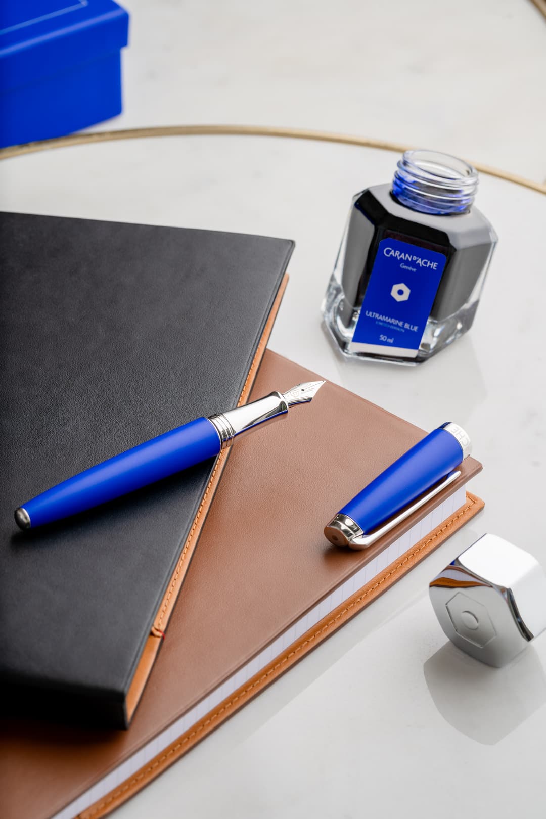 Stylo-plume et stylo-bille Léman Caran d'Ache bleu outremer, accompagnés d'un encrier et de carnets