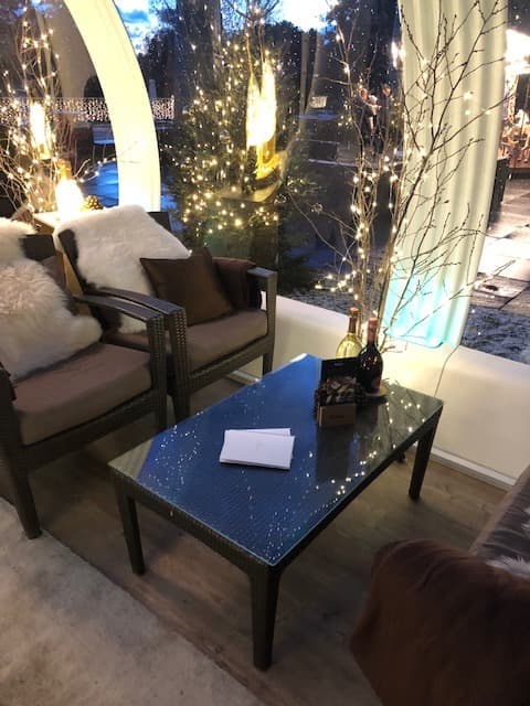 Bulle Ruinart Evasion au Beau-Rivage Palace avec fauteuils, table bleue et guirlandes lumineuses dorées