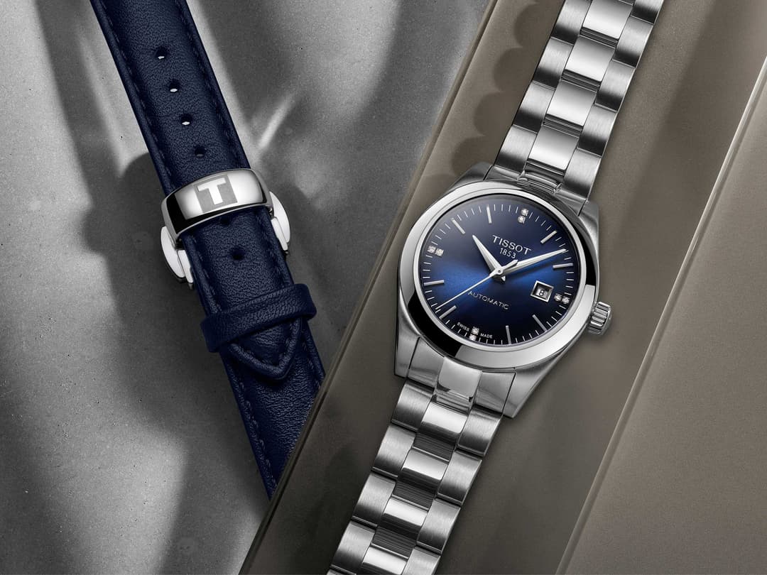 Deux montres Tissot : une T-My Lady avec bracelet cuir bleu marine et une T-Touch Connect Solar avec boîtier et bracelet acier argenté, cadran bleu foncé