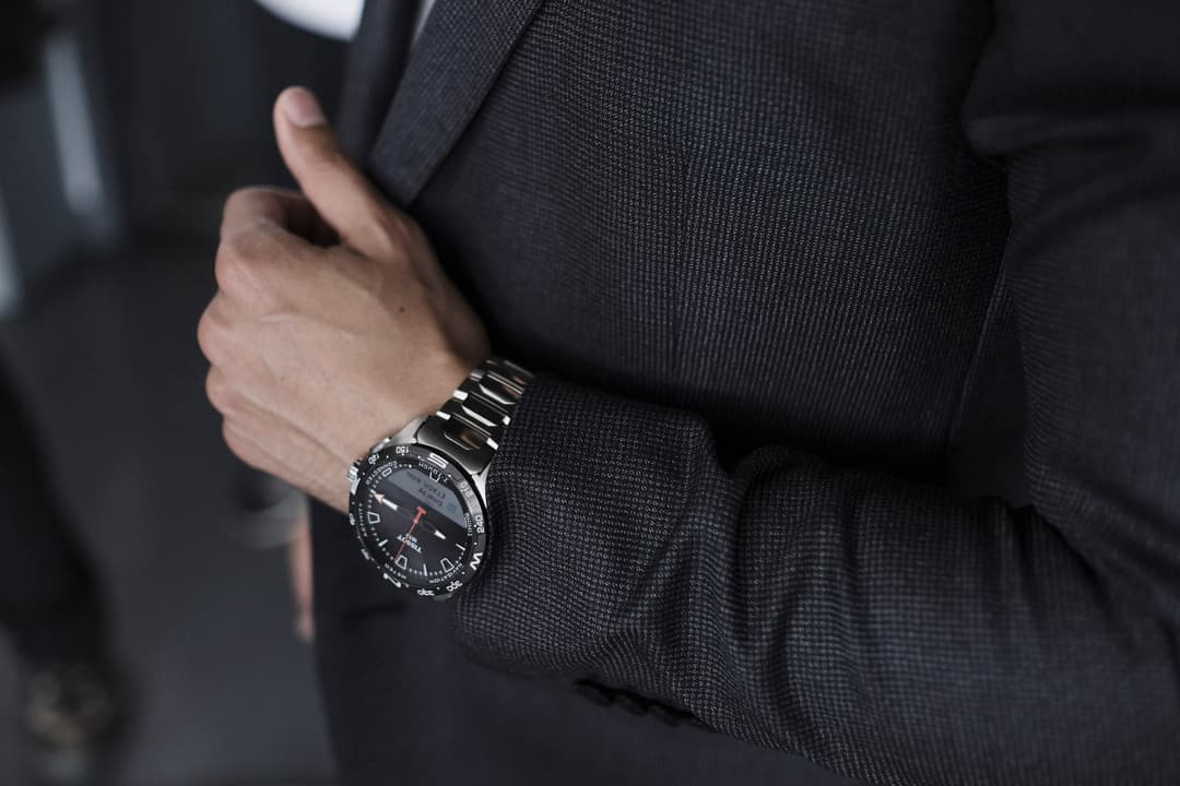 Montre Tissot T-Touch Connect Solar au poignet d'un homme vêtu d'un costume noir